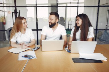 Genç ekip birlikte çalışıyor ve bilgisayarı kullanıyor.