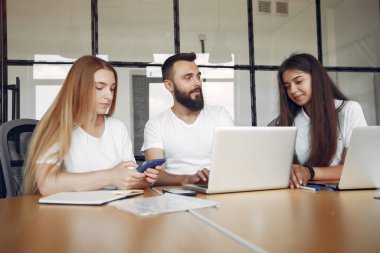 Genç ekip birlikte çalışıyor ve bilgisayarı kullanıyor.