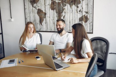 Genç ekip birlikte çalışıyor ve bilgisayarı kullanıyor.