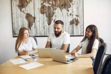 Genç ekip birlikte çalışıyor ve bilgisayarı kullanıyor.