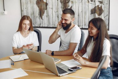 Genç ekip birlikte çalışıyor ve bilgisayarı kullanıyor.