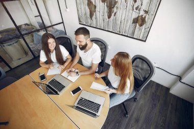 Genç ekip birlikte çalışıyor ve bilgisayarı kullanıyor.