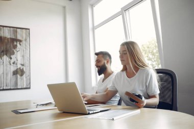 Birlikte çalışan gençler dizüstü bilgisayarlarını kullanıyorlar.