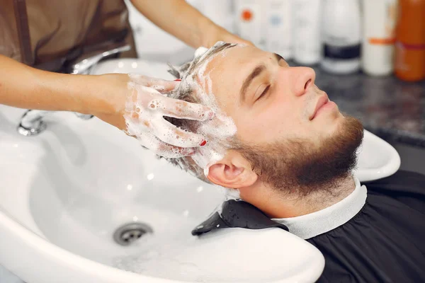 Woma lavando a cabeça dos homens em uma barbearia — Fotografia de Stock