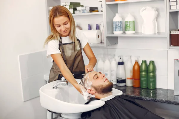 Woma lavaggio mans testa in un barbiere — Foto Stock