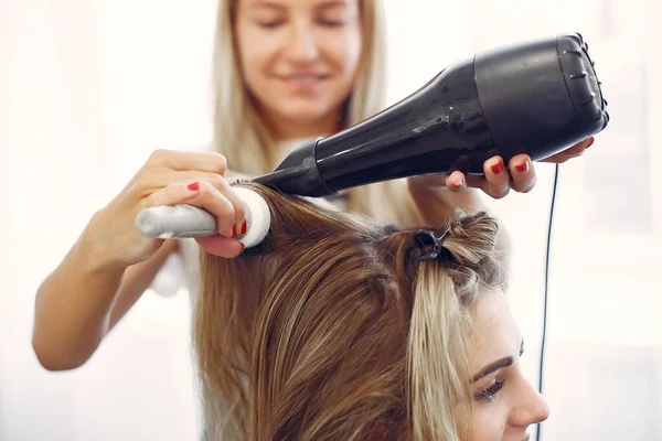 Женщина сушит волосы в парикмахерской — стоковое фото