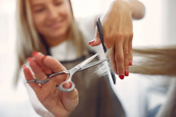 Fryzjer obciąć włosy jej klienta w salonie fryzjerskim — Zdjęcie stockowe