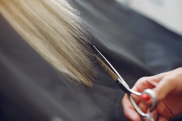 Cabeleireiro cortar cabelo seu cliente em um salão de cabeleireiro — Fotografia de Stock