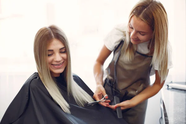 Cabeleireiro cortar cabelo seu cliente em um salão de cabeleireiro — Fotografia de Stock