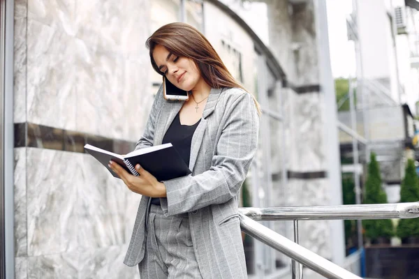 Elegante empresaria que trabaja en una ciudad y usa el cuaderno — Foto de Stock