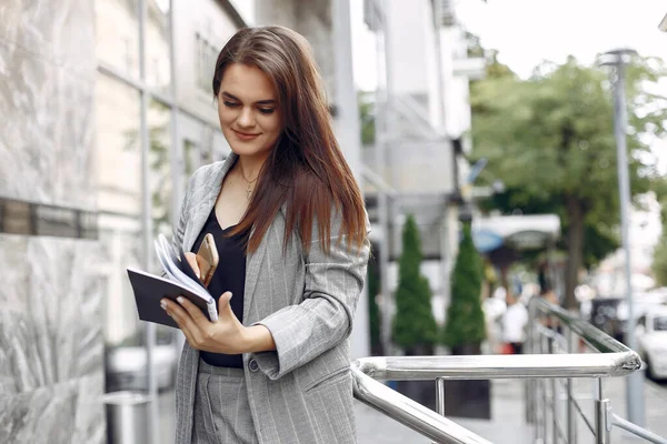 Elegante empresaria que trabaja en una ciudad y usa el cuaderno —  Fotos de Stock