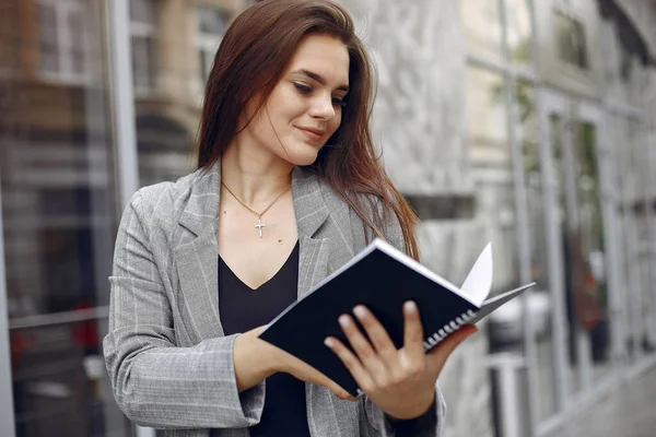 Elegante empresaria que trabaja en una ciudad y usa el cuaderno —  Fotos de Stock