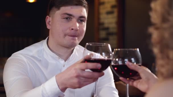 Beyaz gömlekli bir adamın portresi kırmızı şarap içiyor. — Stok video