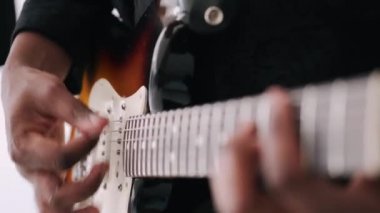 Stüdyoda gitar çalan erkek elleri.
