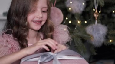 Pembe kutuyu hediyeyle açan kızın görüntüsü.