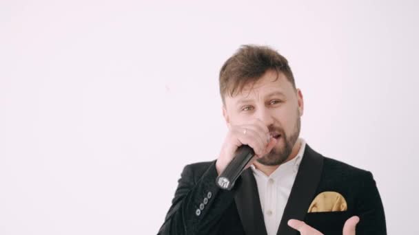 Portrait of man in suit holding microphone and singing song — Stock Video