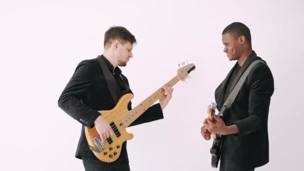 Dois guitarristas em ternos pretos cantando música em estúdio — Vídeo de Stock