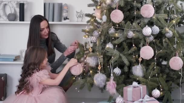 Μητέρα και κόρη στολίζουν το χριστουγεννιάτικο δέντρο μαζί στο σπίτι — Αρχείο Βίντεο