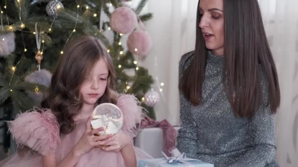 女孩抱着她的母亲，看着她的玻璃球 — 图库视频影像