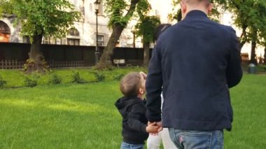 Baba, oğluyla çimlerin üzerinde eğleniyor.