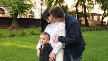 Aile yasaların önünde duruyor ve baba anneyi öpüyor.