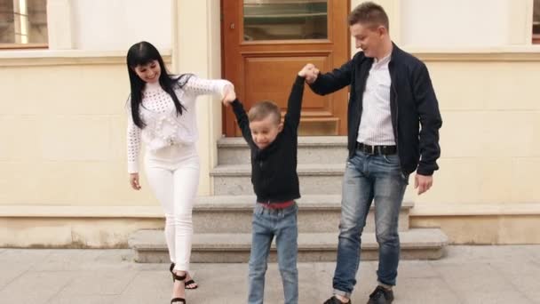 Les parents européens marchent avec leur fils dans la ville — Video