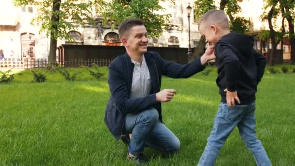 O pai está se divertindo com o filho no gramado — Vídeo de Stock