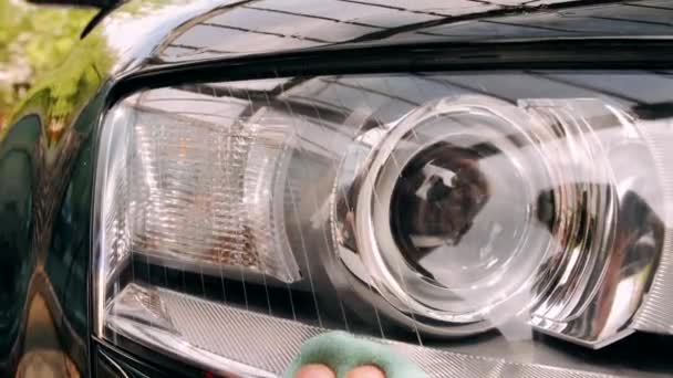 Zbliżenie do mycia reflektorów samochodowych czarnego samochodu — Wideo stockowe