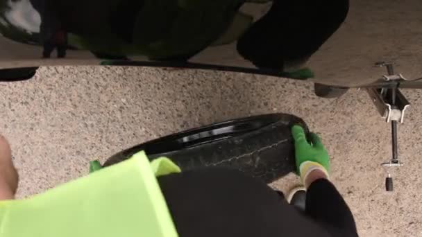 Чоловік міняє шину у своїй машині після зняття плоскої — стокове відео