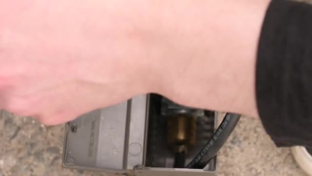 Мужчина обманывает давление в шинах манометром. — стоковое видео