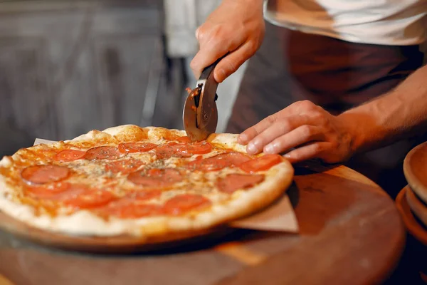 Beyaz üniformalı şef bir pizza hazırla.