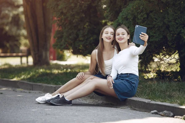 Twee elegante en stijlvolle meisjes in een lentepark — Stockfoto