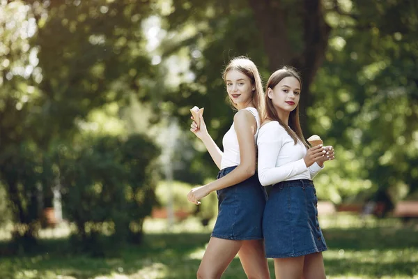 Twee elegante en stijlvolle meisjes in een lentepark — Stockfoto
