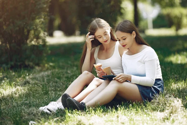 Två eleganta och eleganta tjejer i en vårpark — Stockfoto