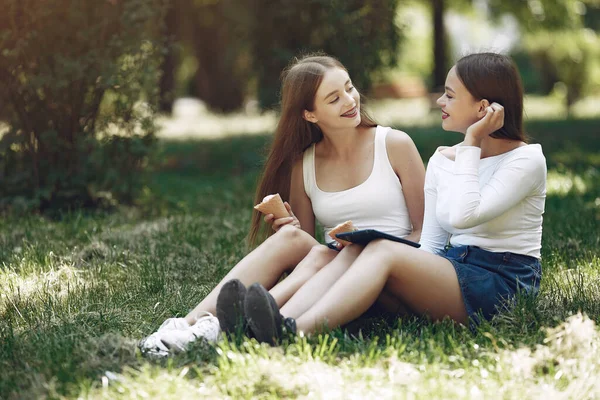 Twee elegante en stijlvolle meisjes in een lentepark — Stockfoto