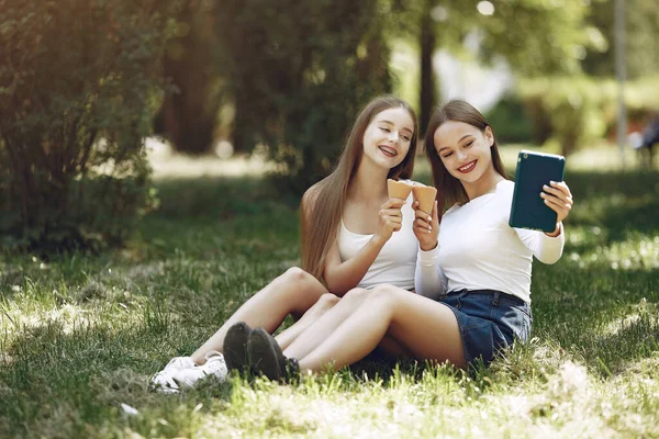 Två eleganta och eleganta tjejer i en vårpark — Stockfoto