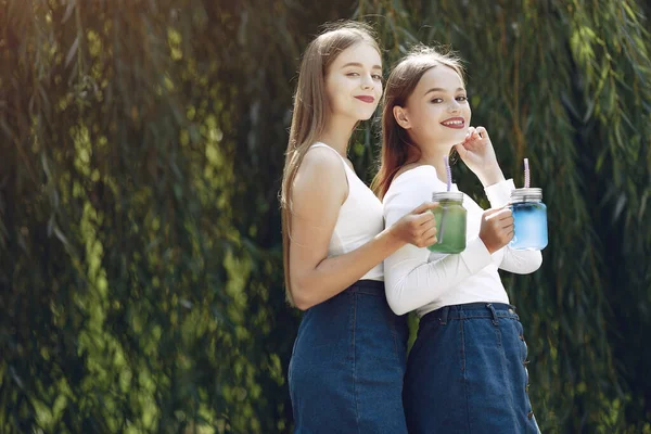 Due ragazze eleganti ed eleganti in un parco primaverile — Foto Stock