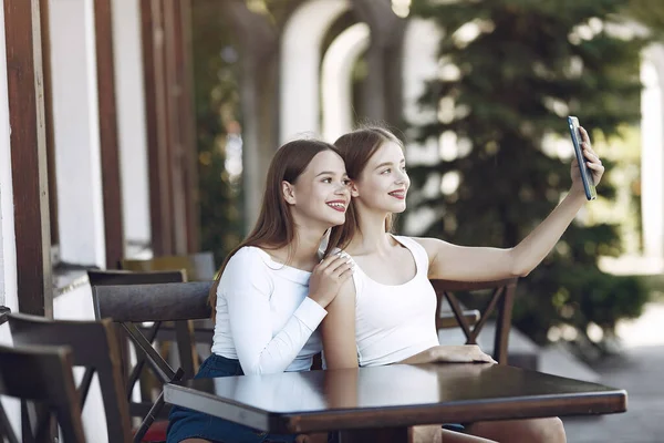 Dwie eleganckie i stylowe dziewczyny w letniej kawiarni — Zdjęcie stockowe