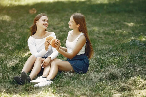 Due ragazze eleganti ed eleganti in un parco primaverile — Foto Stock