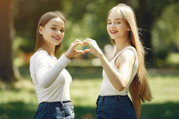 Twee elegante en stijlvolle meisjes in een lentepark — Stockfoto