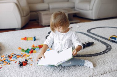 Çocuk oyun odasında kitapla oynuyor.