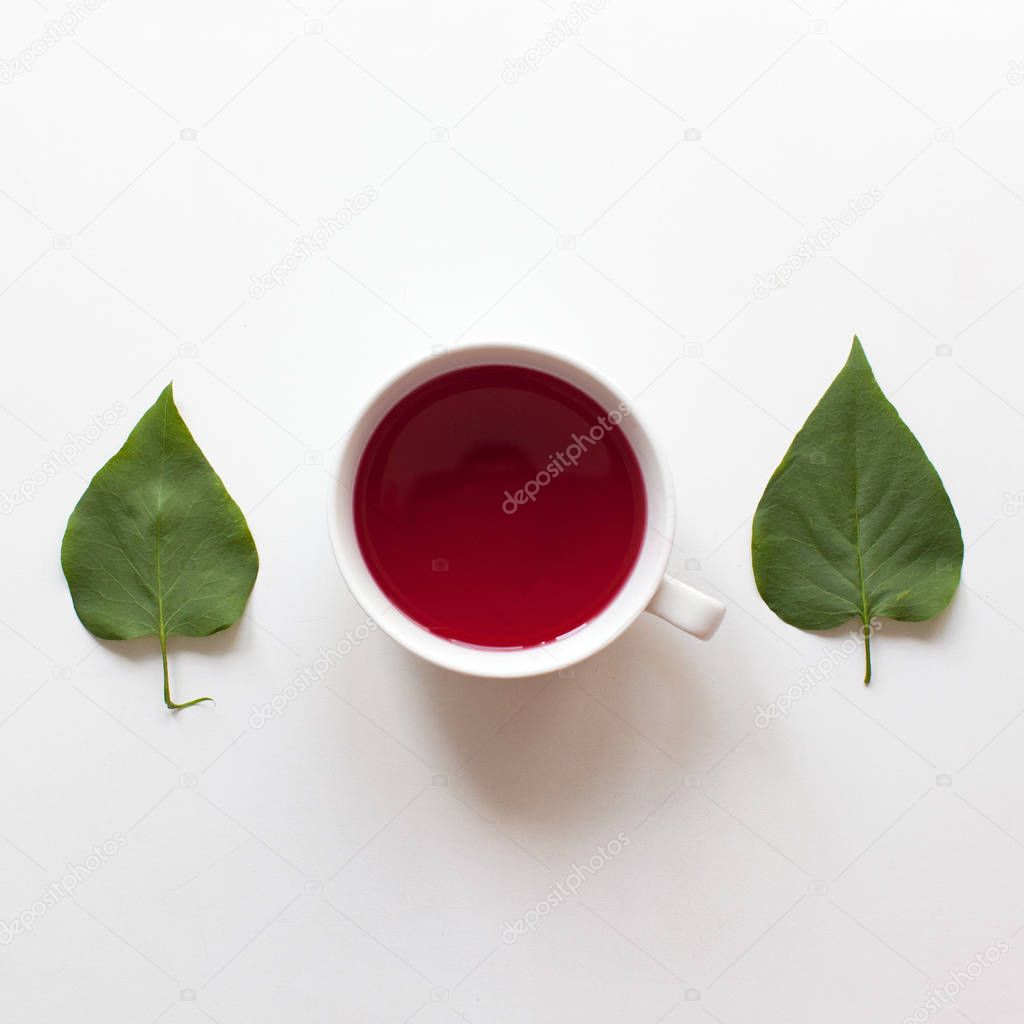 Red fruit tea drink cup. Green leaves