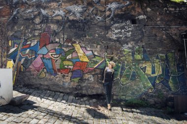 Istanbul, Türkiye - 10 Nisan 2015: Asyalı kadın turist ve Istanbul'da Graffiti sanat