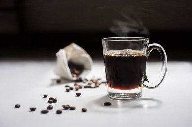 Kahve çekirdeği ve kahve fincanı beyaz arka plan üzerinde bir çuval