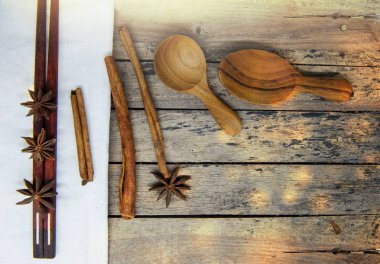 Baharat - tarçın ve anasonu tahta kaşıklar, vintage ahşap masa üzerinde yemek çubukları ile Isınma.
