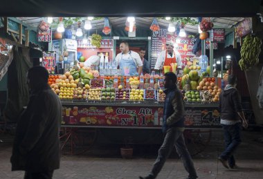 Marakeş, Fas - 13 Nisan 2018 - Jamaa el Fna, Marakeş 'in Medine bölgesinde (eski şehir) bir pazar yeridir. Akşamları bir sürü yiyecek standı, taze meyve, sokak gösterileri, loca kalabalıklarını cezbediyor.