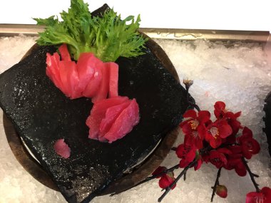 Taze ton balığı çiğ Sashimi buzdaki siyah taş tahtada servis edilir.