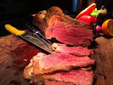 Tahta kesme tahtasının üzerinde, bıçaklı, limonlu, büyük kırmızı soğanlı, kırmızı yeşil capcicum etli sulu slaytlar. Yemek fotoğrafçılığı tarifi fikri.