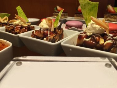 Mini karışık tatlılar ve yemek büfesi üzerine fırın. Küçük bardakta bir lokma.