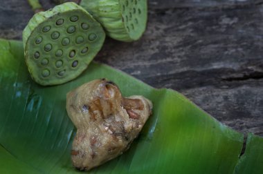 Zongzi ya da geleneksel Çin Yapışkan Pirinç Hamur köfteleri muz yaprağına sarılıp nilüfer tohumu ile süslenmiştir.